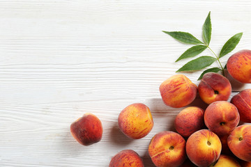 Bunch of ripe organic peaches in pile on wood textured table. Local produce harvest heap. Clean eating concept. Background, top view, close up, copy space, flat lay.
