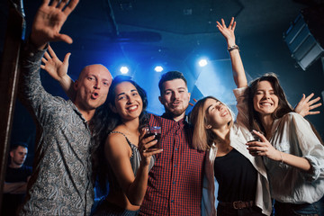 Dancing, drinking and having fun. Beautiful youth have party together with alcohol in the nightclub