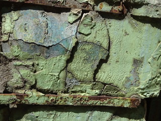 Old aged weathered damage damaged green color concrete wall with metal steel iron construction surface with cracks paint crackle background