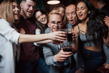 Imagine if every day will be a weekend. Group of young friends smiling and making a toast in the nightclub