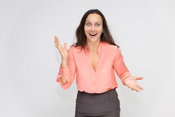 Portrait to the waist a young pretty brunette manager woman of 30 years in business clothes with beautiful dark hair. Standing on a white background, talking, showing hands, with emotions.