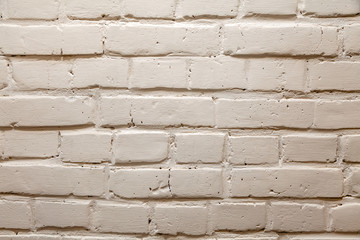 The background is made of yellow, white or gray bricks with a wavy relief, cracks, holes and ditches. Building material for decoration and decor in the style of a loft.