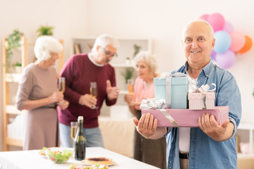 Senior smiling man with several packed gifts