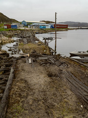 Dilapidated buildings in the port on the coast of the Barents Sea