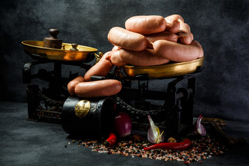 heap of raw short thick wieners in spiral with onion and chili