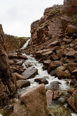 Stormy waters of the northern waterfall in a rocky gorge on the shores of the cold sea
