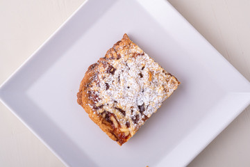 One single pieces of homemade cookies apricot jam powdered sugar in white square plate