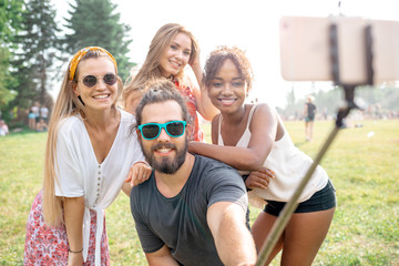 Group of friends taking a selfie using stick