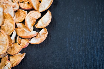 getrocknete äpfel auf schwarzem steinhintergrund