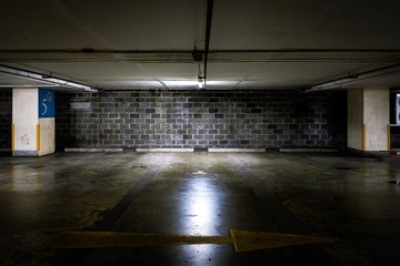 Parking lot cars in building  with light and dirty brick wall background
