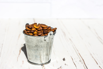 Bucket with roasted coffee beans on a white background.