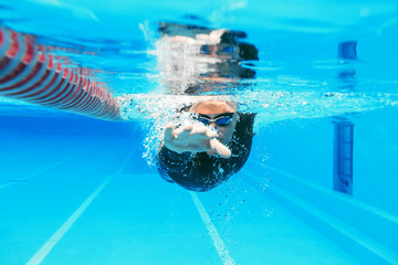 Unterwasseransicht des professionellen männlichen Schwimmers ,training im Swimmingpool - obrazy, fototapety, plakaty