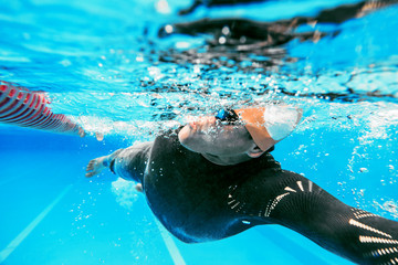 underwater view of professional male swimmer training in swimming pool 