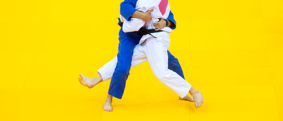 Fototapeta na wymiar Two judo fighters in white and blue uniform.