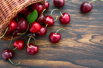 Cherries in the basket pot isolated on old wooden background.