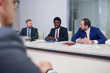 Group of contemporary traders listening to their African colleague