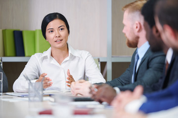 Young confident mixed-race businesswoman answering questions