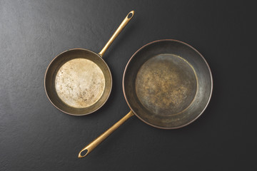 Rustic frying pans on black background