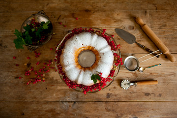 Bundt cake with currant and roses flowers on the black background.