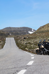 Norwegian Scenic Route Aurlandsfjellet 243 runs across the mountains. Motorcycles parked on a roadside, white line. Norway, Scandinavia