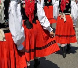 Group of women walk in traditional Polish  folk costumess 