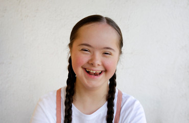 Portrait of little girl smiling on background of the wall