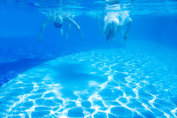 Underwater shot of young people diving in a pool