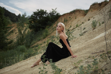 Attractive young woman on the sand. Fashion portrait
