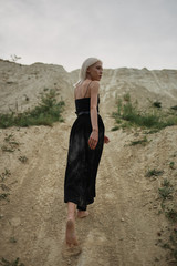Attractive young woman on the sand. Fashion portrait