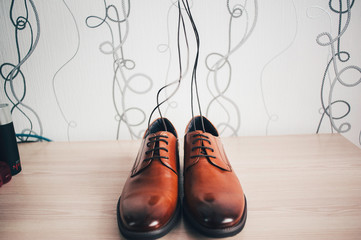 stylish wedding brown male shoes lying on a light table. background. Accessories groom. lacing...