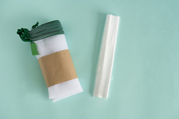 white transparent weaving kapron bags for multiple use when buying and storing fruits and vegetables to lie on a blue background next to plastic bags