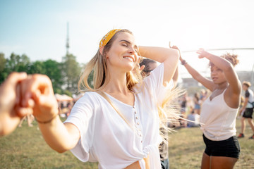 Obraz premium Beautiful young long haired woman dancing with friends outdoor at music festival