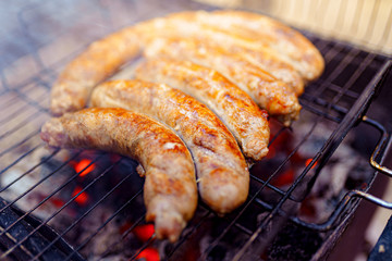 Grilled sausage on the picnic flaming grill outdoor