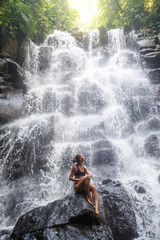 Fototapeta na wymiar Woman near waterfal on Bali, Indonesia 