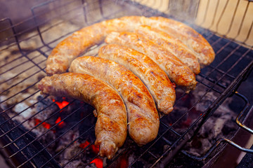 Grilled sausage on the picnic flaming grill outdoor
