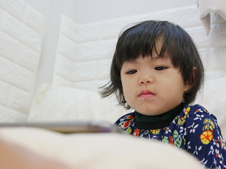 Little baby girl's face, 2 years old, while watching / staring at a smartphone