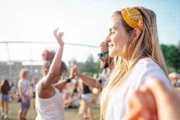Fototapeta premium Beautiful young long haired woman dancing with friends outdoor at music festival