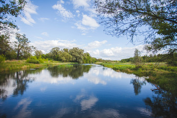 A small river with a slow current, landscape with beautiful blue sky
