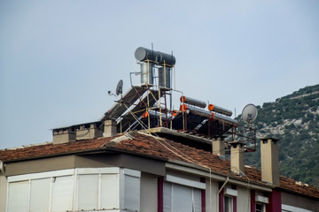 Steel barrels of boilers with water on the roof of a building to heat water