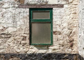 Old window in a whitewashed wall