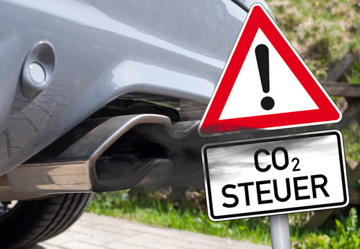 Autoauspuff mit Abgaswolke und Schild CO2 Steuer