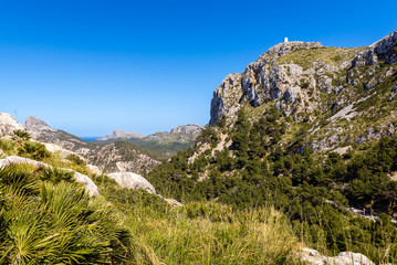Fototapeta na wymiar Mountains with tower on the top in north east of Mallorca. Cap de Formentor. Spain