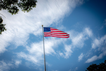 american flag waving in the wind in front of blue sky