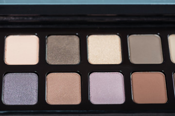 Neutral color eye shadows palette on grey background