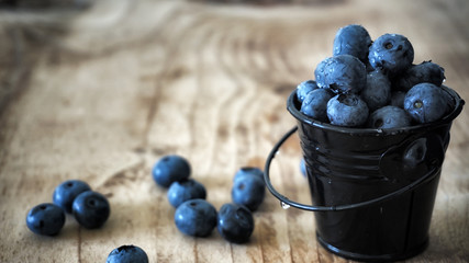 Combination of blueberries and cranberries rolled over on wooden table
