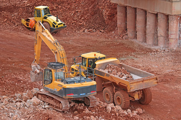 digger loading a dump truck on a road construction site