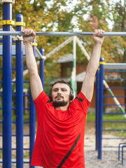Obraz premium Young athletic man doing sport exercises outdoors in the park