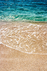 Soft waves of blue clear sea on sandy beach. Summer Background.