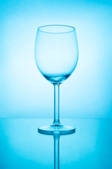 Empty wine glass with reflection in blue light