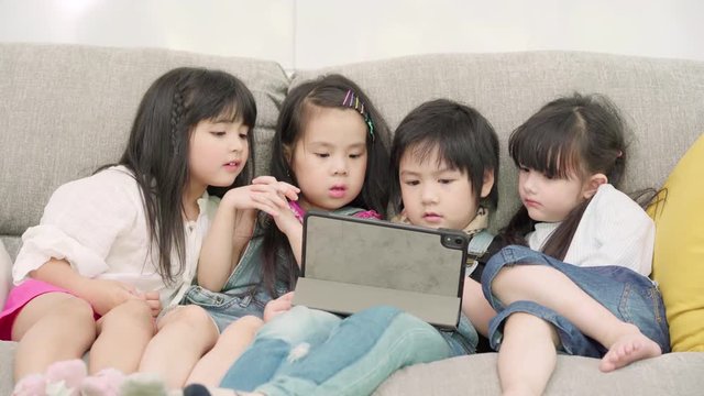 Group of children using tablet in classroom, Multi-ethnic young boys and girls happy using technology for study and play games at elementary school. Kids use technology for education concept.